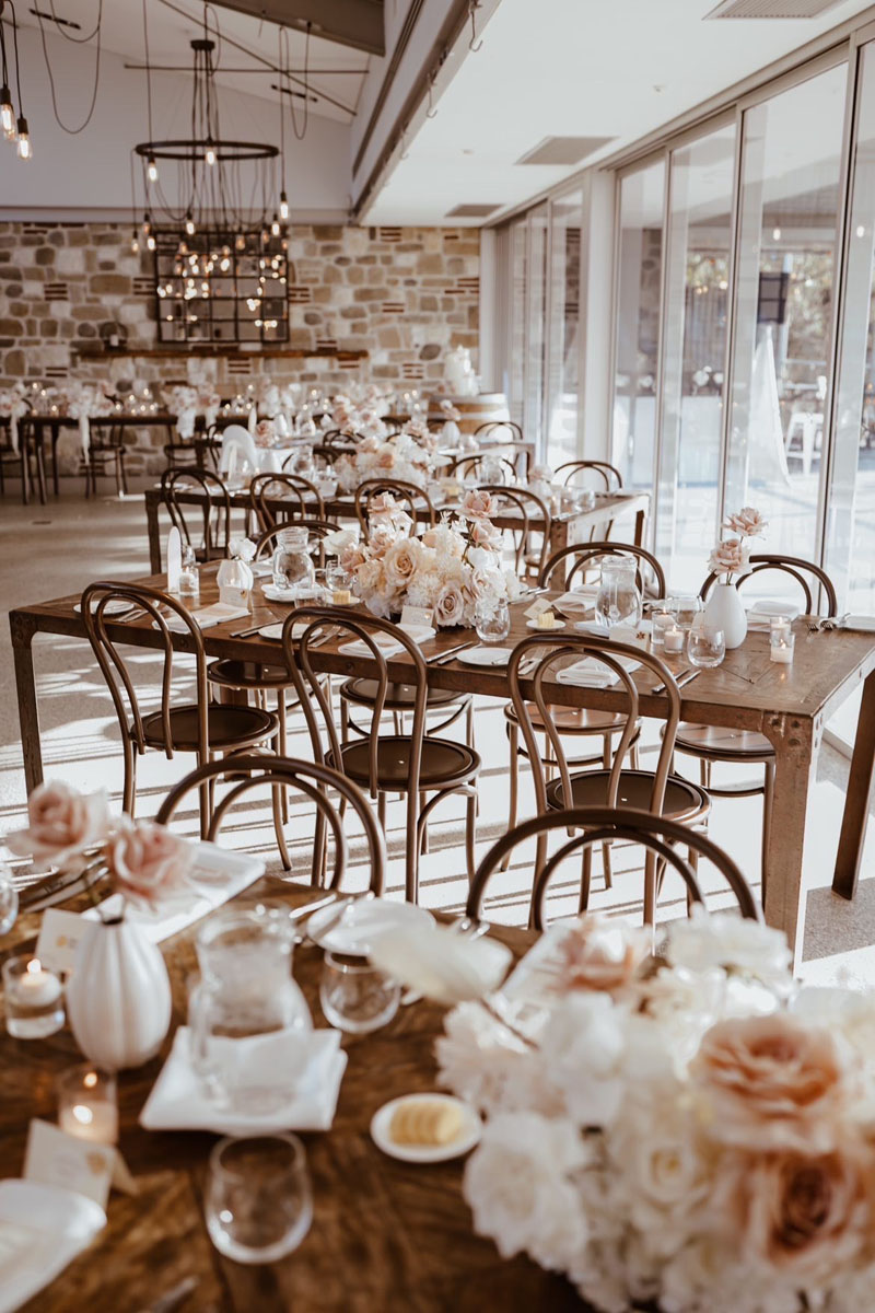 Long timber wedding table set for reception in the rustic ballroom at The Springs